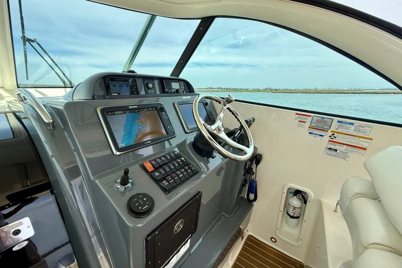 Slide: The Image of Helm of 2012 Pursuit OS 345 Offshore boat with navigation controls and steering wheel. - 48