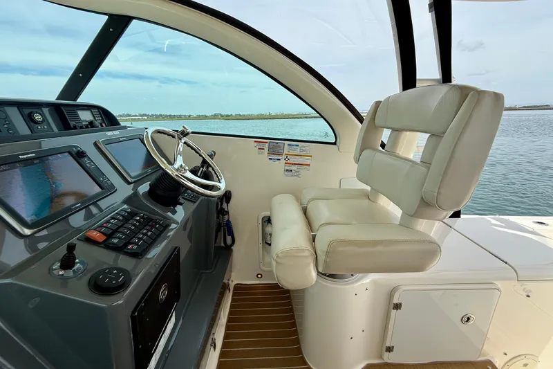 Slide: The Image of 2012 Pursuit OS 345 Offshore helm with steering wheel and navigation screens. - 49