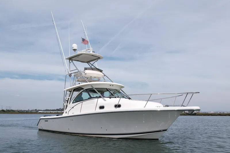 Slide: The Image of 2012 Pursuit OS 345 Offshore boat on calm water under a clear sky. - 5