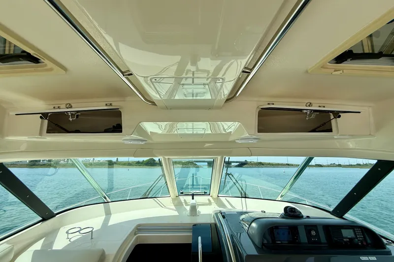 Slide: The Image of Interior view of 2012 Pursuit OS 345 Offshore boat, showcasing helm and open storage compartments. - 50