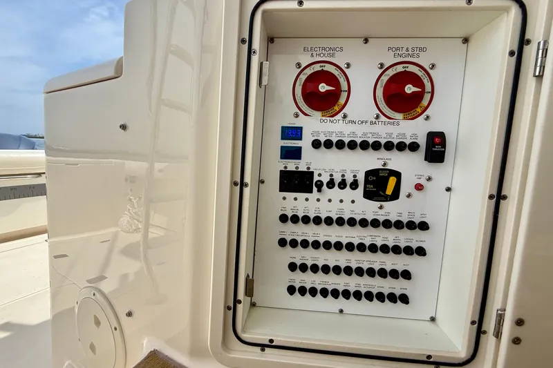 Slide: The Image of Control panel of a 2012 Pursuit OS 345 Offshore boat, featuring switches and battery controls. - 56