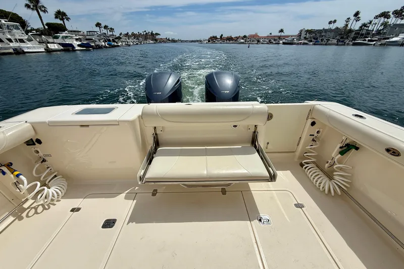 Slide: The Image of 2012 Pursuit OS 345 Offshore boat with dual engines cruising in a marina. - 63