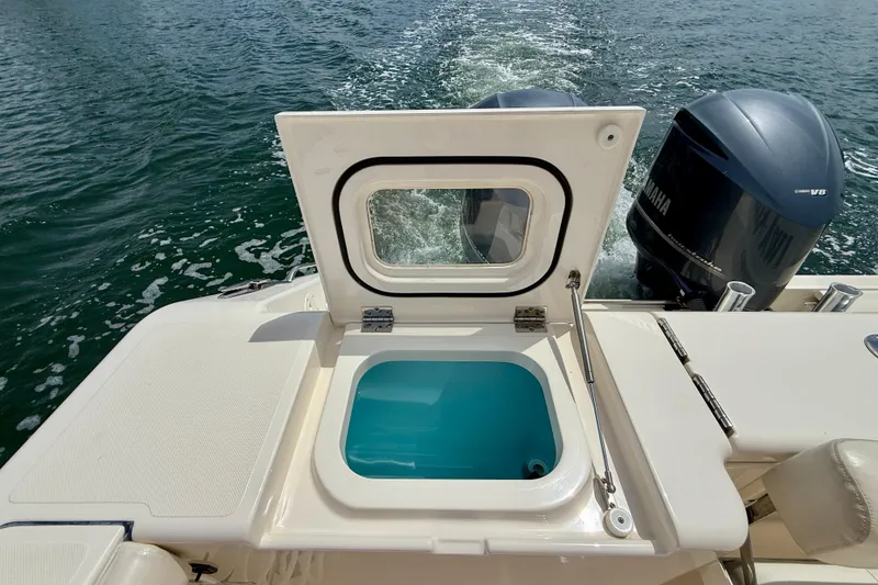 Slide: The Image of 2012 Pursuit OS 345 Offshore boat with open hatch and twin Yamaha engines. - 66