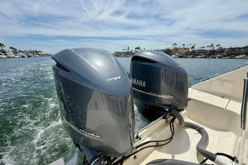 Slide: The Image of Twin Yamaha V8 engines on a 2012 Pursuit OS 345 Offshore boat in a marina. - 68