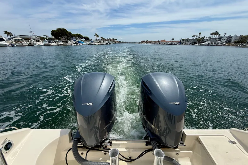 Slide: The Image of 2012 Pursuit OS 345 Offshore boat with twin Yamaha V8 engines cruising in a marina. - 69