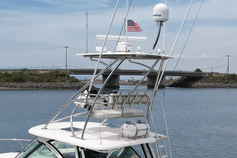 Slide: The Image of 2012 Pursuit OS 345 Offshore boat with radar, American flag, and bridge in background. - 7