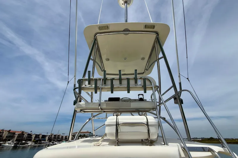 Slide: The Image of 2012 Pursuit OS 345 Offshore boat tower with rod holders under a clear sky. - 71