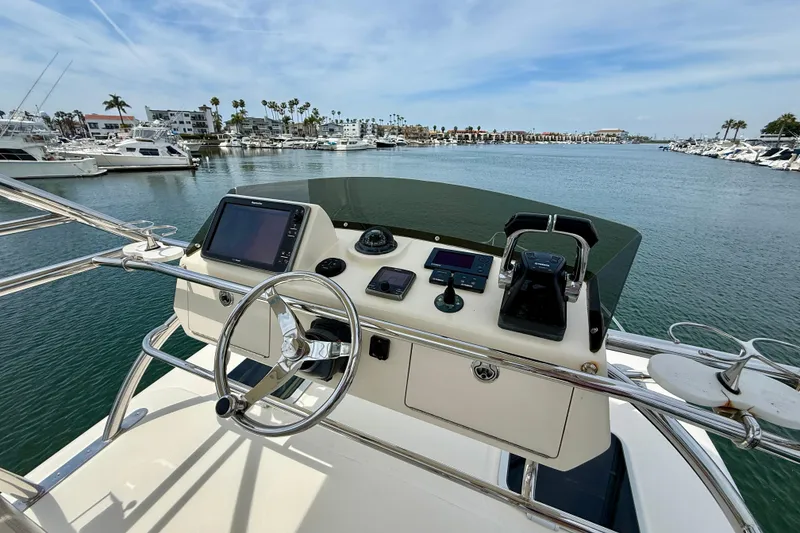 Slide: The Image of Helm of 2012 Pursuit OS 345 Offshore boat with marina view. - 73