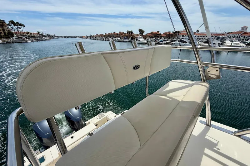 Slide: The Image of 2012 Pursuit OS 345 Offshore boat with beige seating, cruising in a marina. - 77