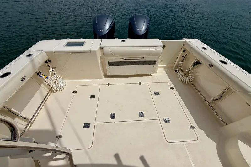 Slide: The Image of 2012 Pursuit OS 345 Offshore boat deck with twin engines on water. - 82