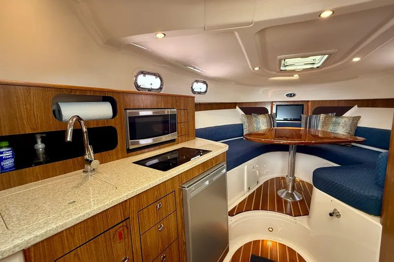 Slide: The Image of Luxurious interior of a 2012 Pursuit OS 345 Offshore boat with kitchen and seating area. - 9