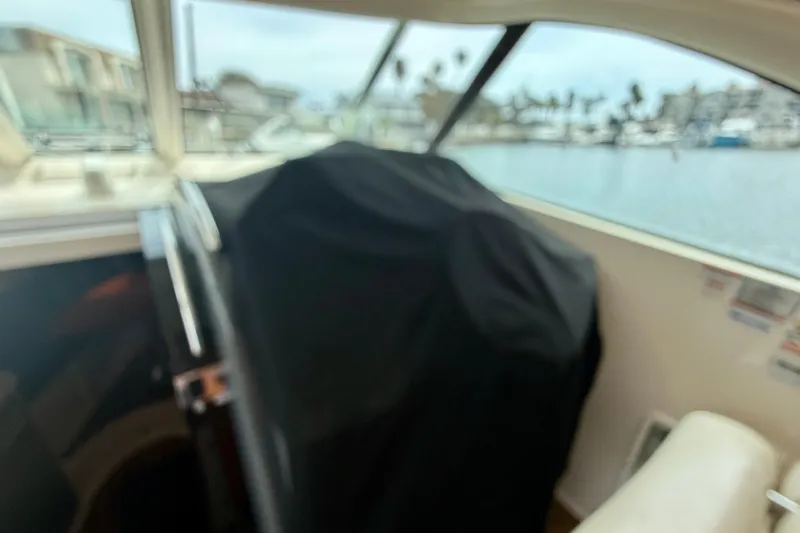 Slide: The Image of Interior view of a 2012 Pursuit OS 345 Offshore boat with covered equipment. - 91