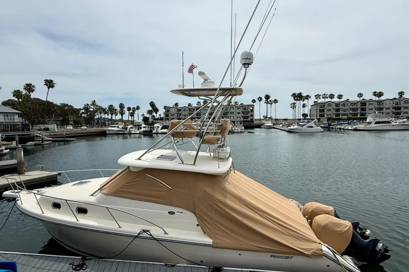 Slide: The Image of 2012 Pursuit OS 345 Offshore boat docked in a marina with palm trees. - 92