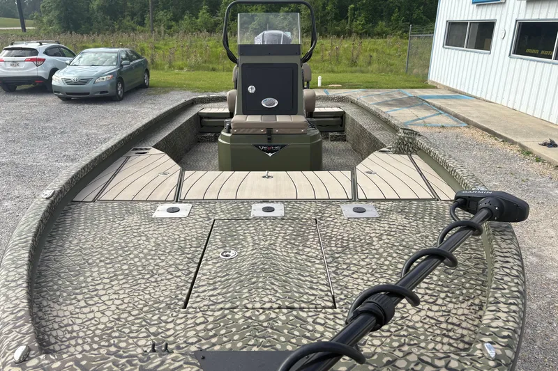 Slide: The Image of 2026 Vexus ACX 2210 boat with camouflage design, parked outdoors near vehicles. - 7