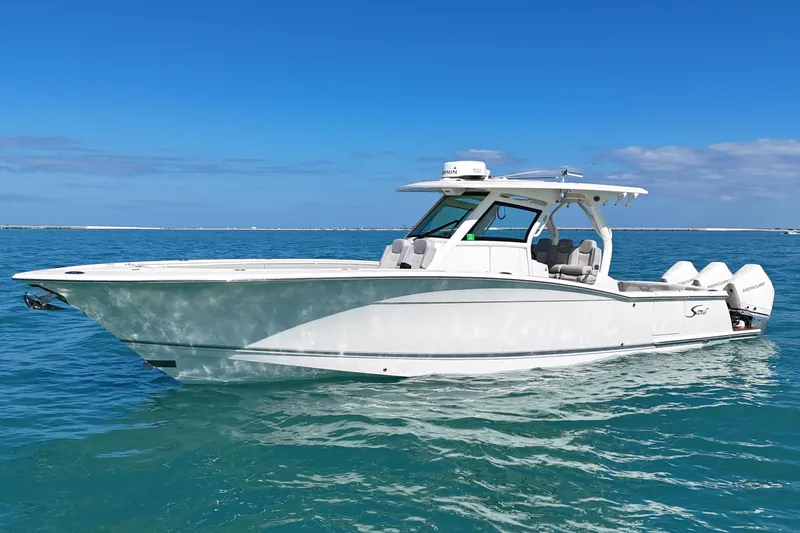 The Image of 2019 Scout 355 LXF boat on clear blue water under a sunny sky. - 0