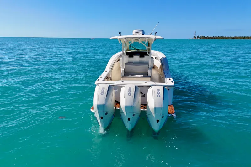 Slide: The Image of 2019 Scout 355 LXF boat with triple engines on turquoise water. - 10