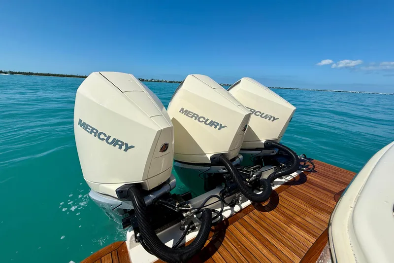 Slide: The Image of 2019 Scout 355 LXF boat with triple Mercury outboard engines on blue water. - 11