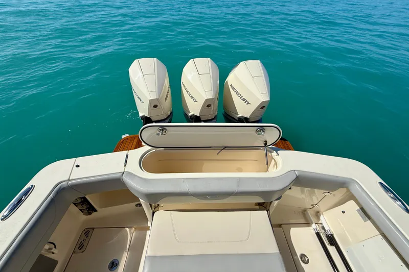 Slide: The Image of 2019 Scout 355 LXF boat with triple Mercury engines on turquoise water. - 14