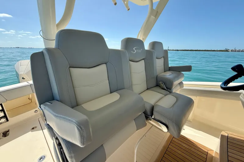 Slide: The Image of Luxury seating on 2019 Scout 355 LXF boat, overlooking serene blue waters. - 17