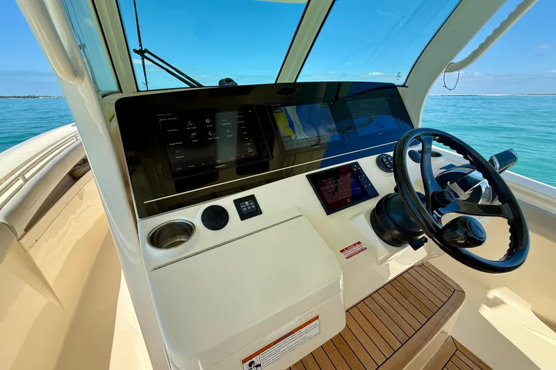 Slide: The Image of 2019 Scout 355 LXF boat helm with modern controls and ocean view. - 19