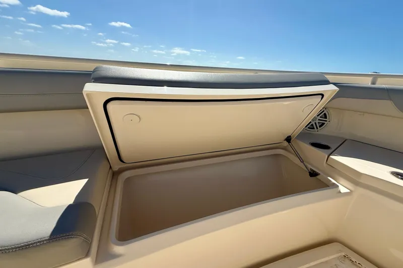 Slide: The Image of 2019 Scout 355 LXF boat storage compartment open under clear blue sky. - 26