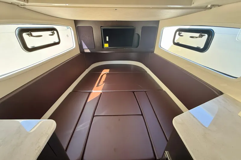 Slide: The Image of 2019 Scout 355 LXF cabin interior with brown seating and windows. - 29