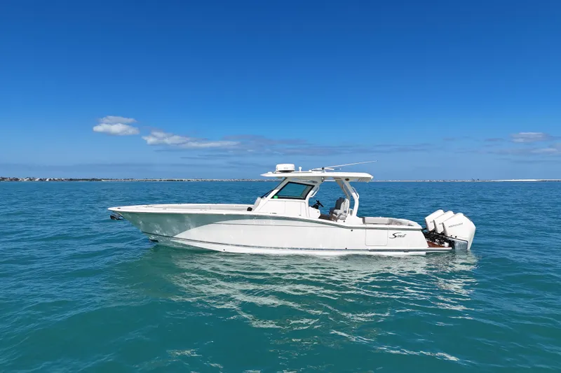 Slide: The Image of 2019 Scout 355 LXF boat on clear blue ocean under sunny sky. - 3