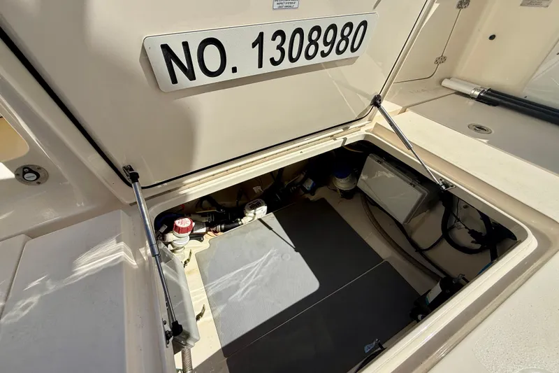 Slide: The Image of Open hatch of 2019 Scout 355 LXF boat showing storage compartment and equipment. - 33