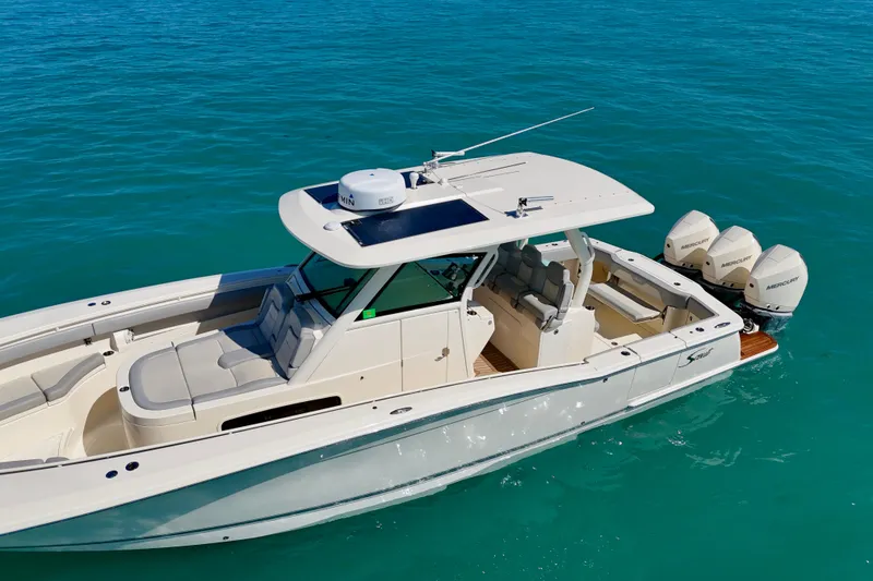 Slide: The Image of 2019 Scout 355 LXF boat on clear blue water, featuring triple Mercury engines. - 4