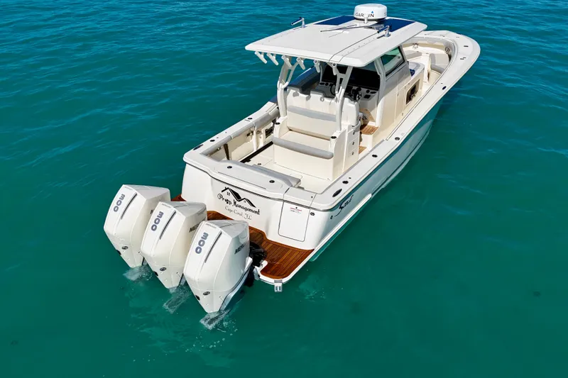 Slide: The Image of 2019 Scout 355 LXF boat with triple Mercury engines on clear blue water. - 8