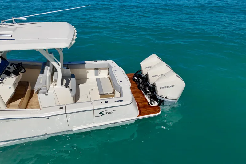 Slide: The Image of 2019 Scout 355 LXF boat with triple Mercury engines on turquoise water. - 9