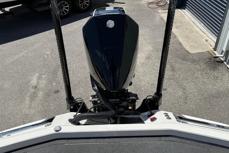 Slide: The Image of 2023 Ranger Z520C Cup-Equipped boat engine and controls, parked on pavement. - 18