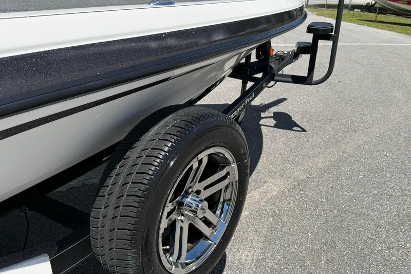 Slide: The Image of 2023 Ranger Z520C Cup-Equipped boat trailer with shiny chrome wheel on asphalt. - 4