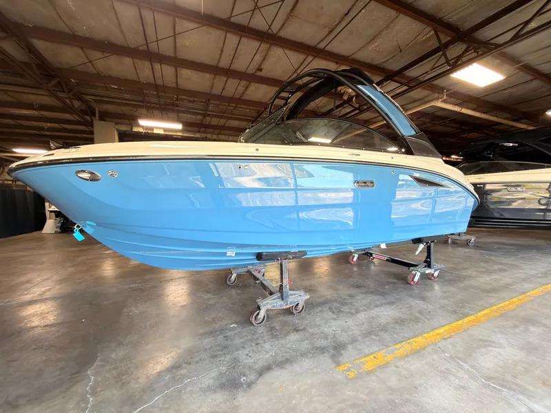 Slide: The Image of A 2026 Sea Ray SDX 230 Surf boat is in a warehouse on dollies. - 3