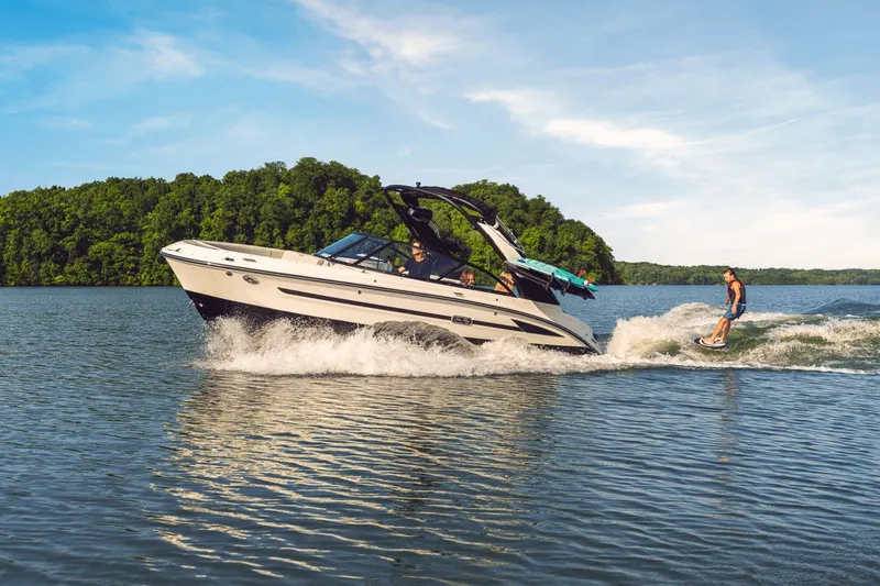 Slide: The Image of 2026 Sea Ray SDX 230 Surf boat with wakeboarder on lake. - 30