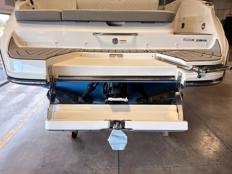 Slide: The Image of The image shows the rear of a 2026 Sea Ray SDX 230 Surf boat with an open engine cover. - 10