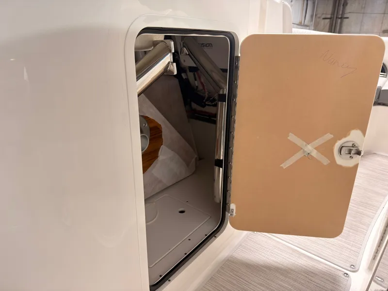 Slide: The Image of An open storage compartment on a Sea Ray SDX 230 Surf boat, revealing interior mechanisms. - 43
