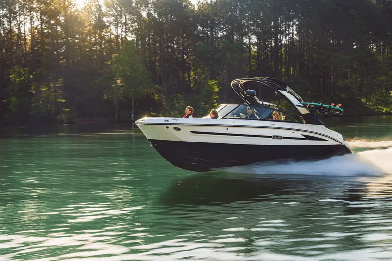 Slide: The Image of 2026 Sea Ray SDX 230 Surf boat cruising on a serene lake. - 46