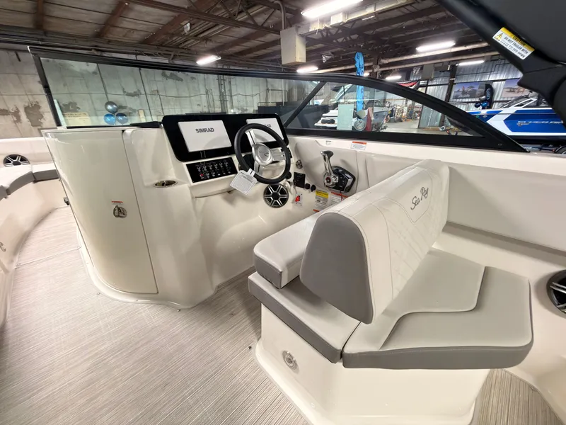 Slide: The Image of The image shows the cockpit of a 2026 Sea Ray SDX 230 Surf with modern controls and gray upholstery. - 26
