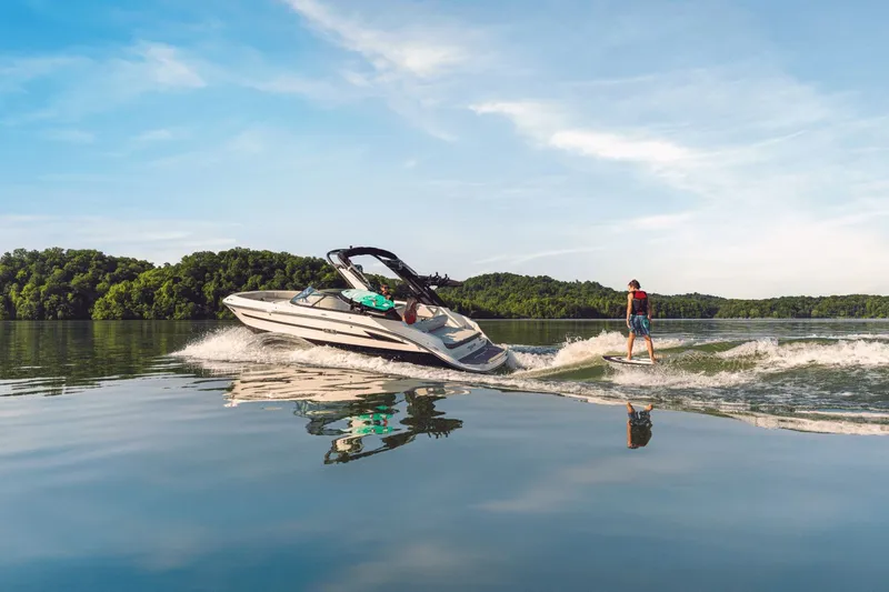Slide: The Image of 2026 Sea Ray SDX 230 Surf boat with wakeboarder on a serene lake. - 6