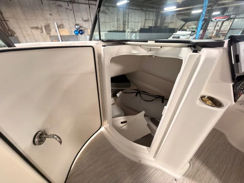 Slide: The Image of The 2026 Sea Ray SDX 230 Surf features an open storage compartment with a door and handle. - 39