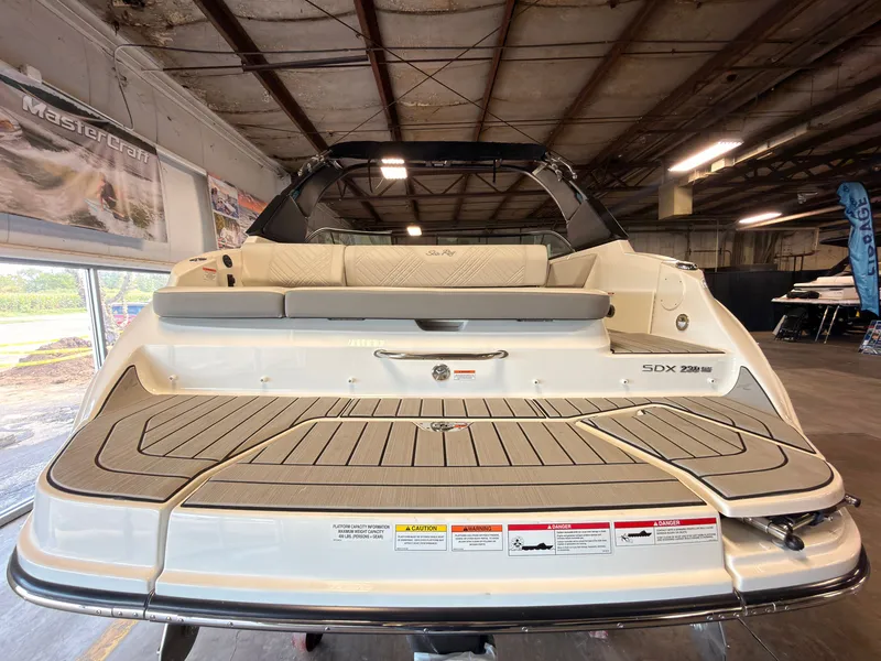Slide: The Image of The image shows the stern of a Sea Ray SDX 230 Surf boat in a warehouse. - 6