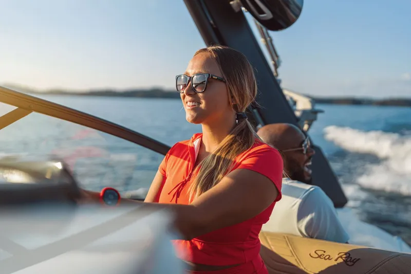 Slide: The Image of Woman piloting Sea Ray SDX 250 Surf boat on open water. - 23