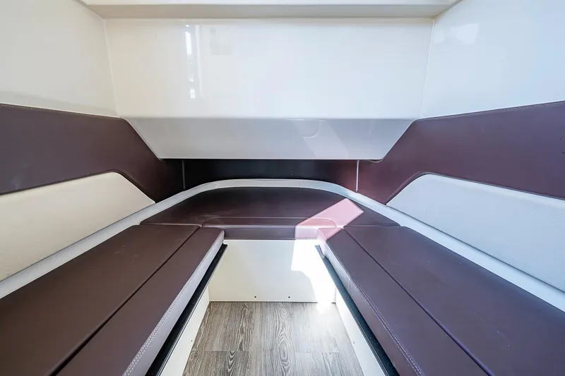 Slide: The Image of 2021 Scout 330 LXF cabin interior with brown and white seating, wood flooring. - 21