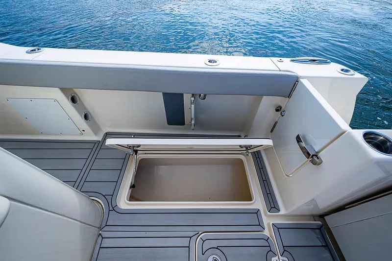 Slide: The Image of 2021 Scout 330 LXF boat interior with open storage compartment by the water. - 33