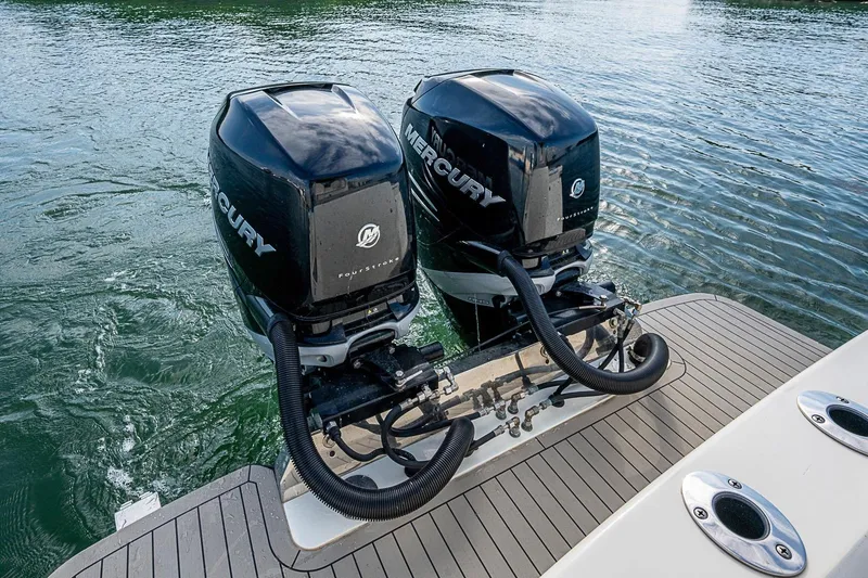 Slide: The Image of Twin Mercury outboard engines on a 2021 Scout 330 LXF boat, docked on water. - 36
