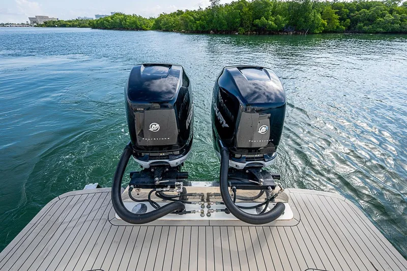 Slide: The Image of 2021 Scout 330 LXF boat with dual Mercury outboard engines on a calm waterway. - 38
