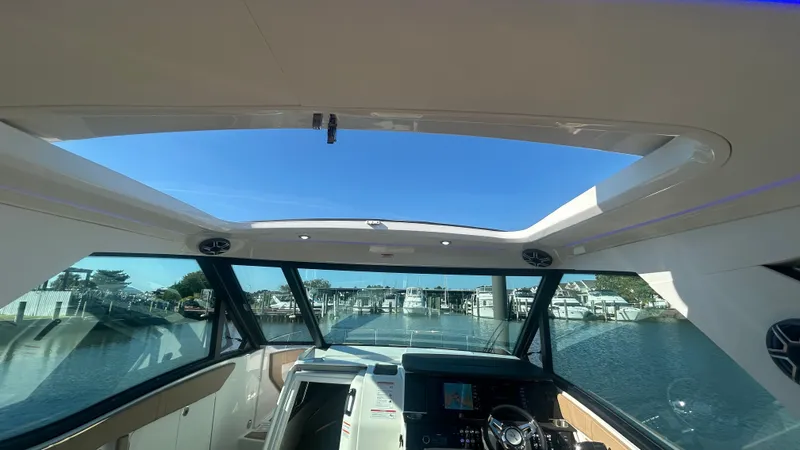 Slide: The Image of The cockpit of the Sea Ray Sundancer 320 Outboard offers a clear view of the marina. - 25