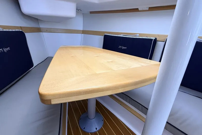 Slide: The Image of Interior of 2016 Catalina 275 Sport with wooden table and blue cushions. - 2