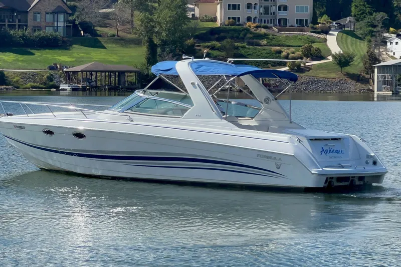 The Image of 2004 Formula 330 Sun Sport boat on a serene lake with scenic background. - 0